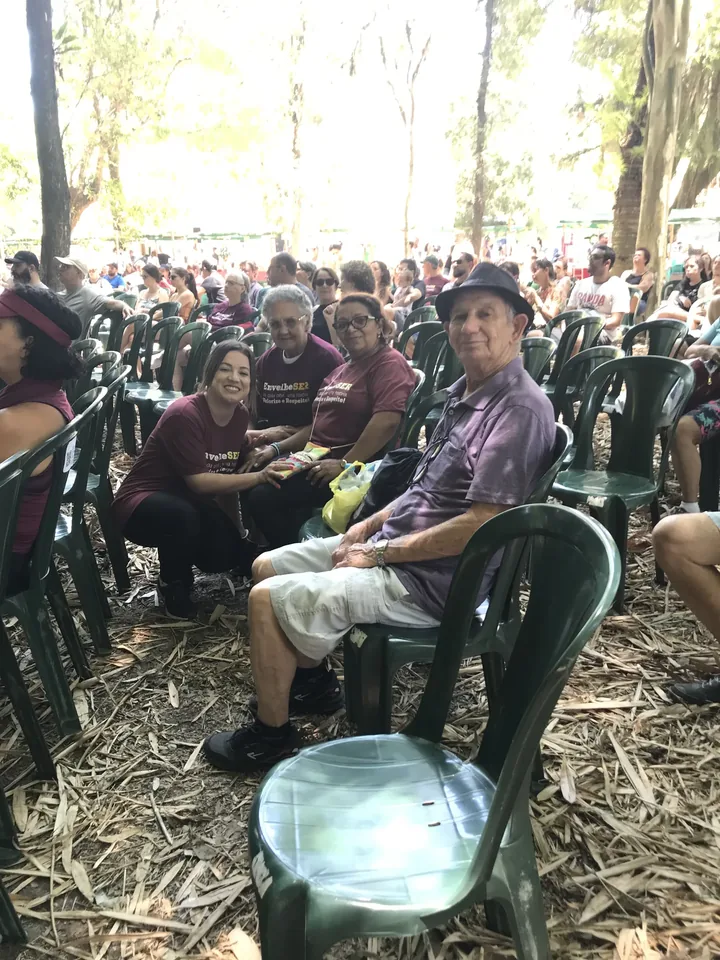 Público sentado sob árvores durante atividade do EnvelheSer