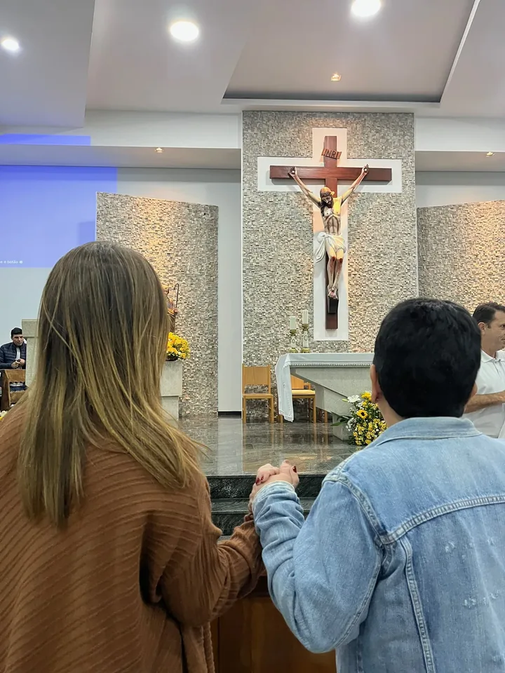 Vanessa Fortes dentro de uma igreja, vista de costas diante do altar