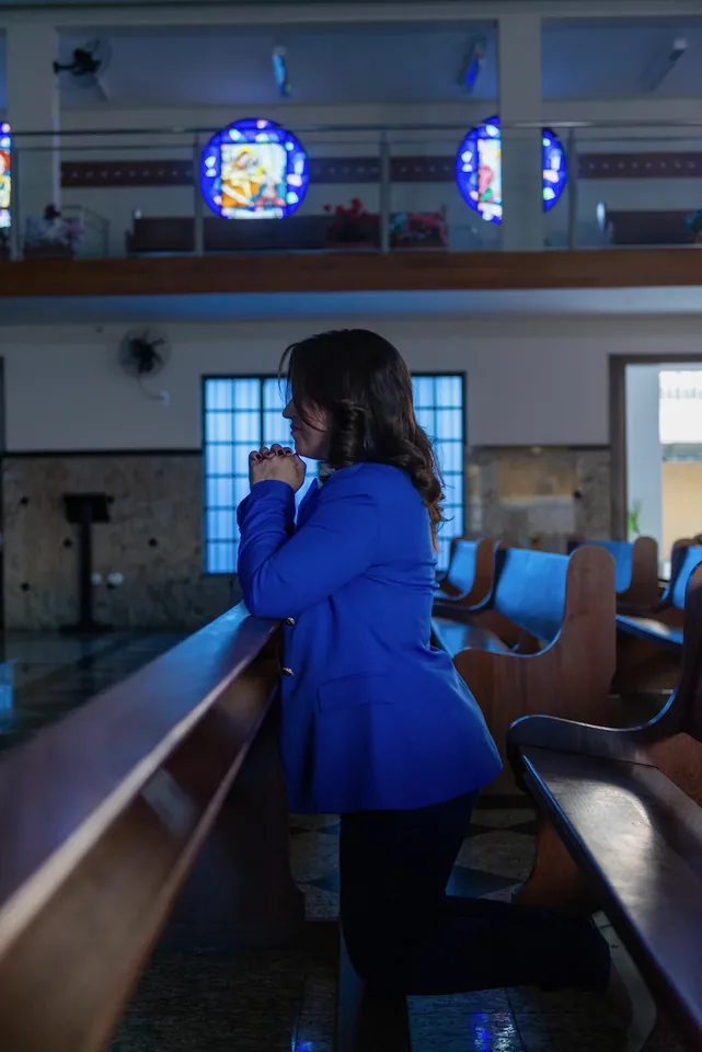 Vanessa Fortes em pé dentro de uma igreja com bancos ao redor