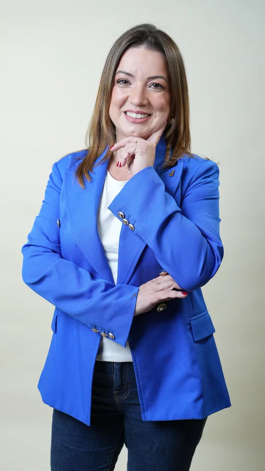 Retrato profissional de Vanessa Fortes usando blazer azul e blusa branca
